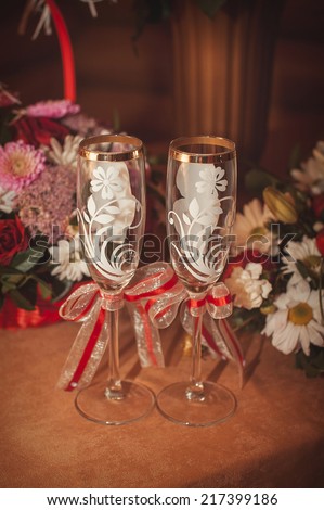 Two glasses and bouquet of the bride on a stone handrail