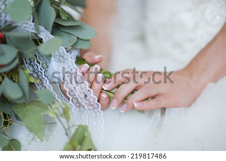 hands of a bride, just married, a bridal bouquet is beside
