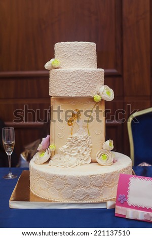 a multi level white wedding cake on a silver base and pink flowers on top