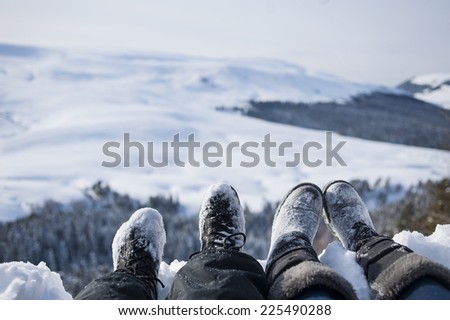 snow-covered feet of two hikers on a winter landscape.