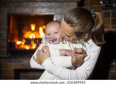 Mom and daughter kissing fireplace.