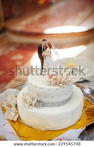 bridal white cake with bride and groom figurines.