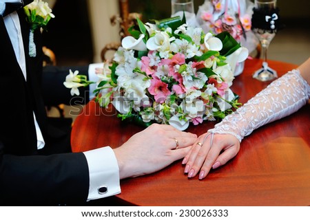 Wedding couple holding hands on bouquet. Groom and Bride in a park. wedding dress. Bridal wedding bouquet of flowers.