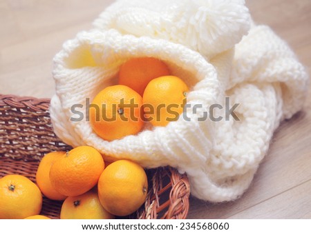 Christmas tangerines and Christmas toys on knitted scarf close-up.