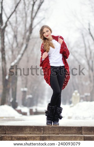 woman in winter in a park in red scarf and red lips.