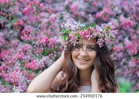 young woman in a park with a spring wreath.