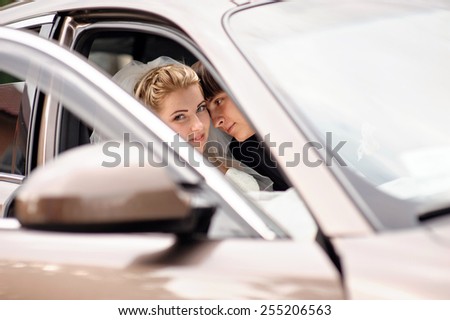 bride and groom kissing in wedding car.