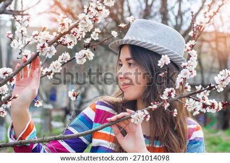Woman in spring blossom. Young naturally beautiful woman near the blooming tree in spring time.