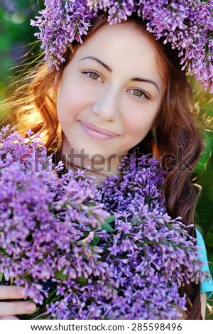 beautiful girl with a bouquet of lilacs and a wreath of lilac.