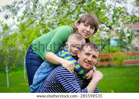young family walks in the spring garden with a child.