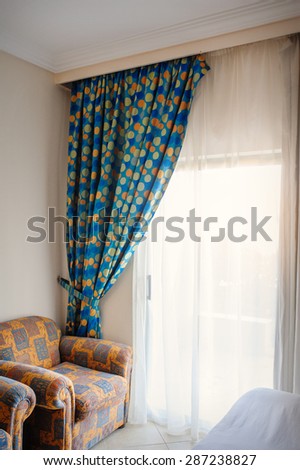 beautiful curtains and chairs in the room.