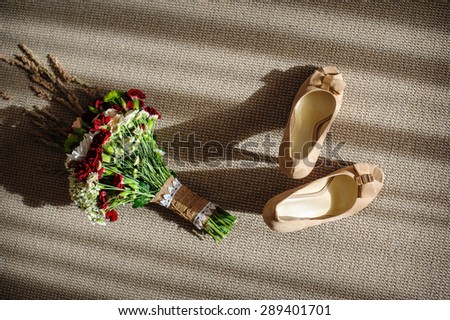 beautiful wedding bouquet and bride\'s shoes near the window.
