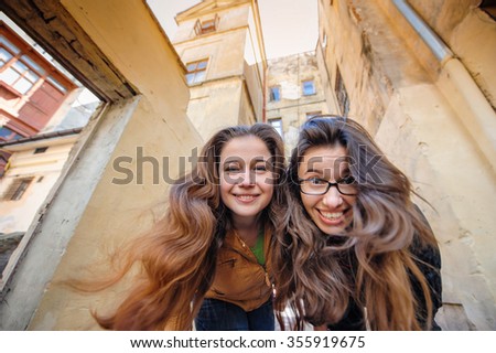 Two happy women walking in old Lviv.