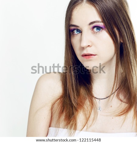 Studio portrait of a pretty young girl on a white background. Professional make-up, purple shadows