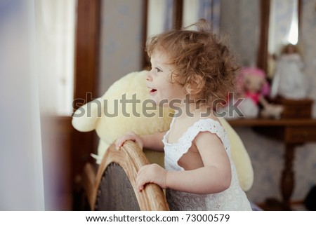 Smiling little girl looks out the window
