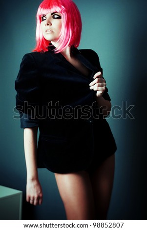 fashion shot of professional model with smoky-eyes makeup, posing in the studio in a pink wig and bright make-up