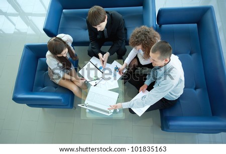 Top view of working business group sitting at table during corporate meeting