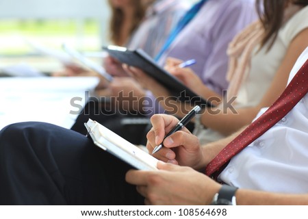 Closeup of executive writing notes during business meeting
