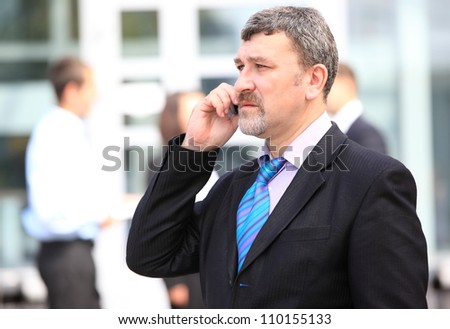 A handsome business man on phone at office building