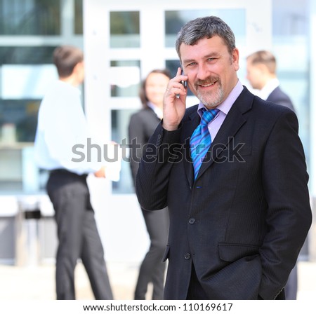 A handsome business man on phone at office building