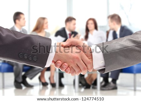 Closeup of business people shaking hands over a deal