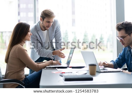 Sharing opinions. Group of young modern people in smart casual wear discussing business while working in the creative office