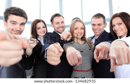 Happy diverse group of executives all pointing at you