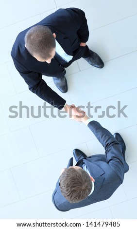 Top View Of A Two Businessman Shaking Hands - Welcome To Business