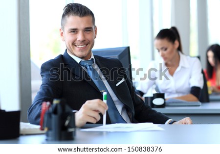 Happy businessman sitting in office