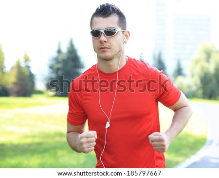 Sport - Runner. Man running with concentration, determination and strength towards goals and success in marathon. Fit male sport fitness model sprinting outdoors.