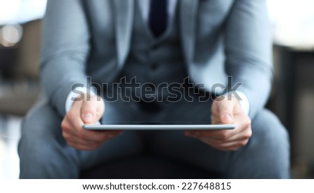 Young adult working on a digital tablet. Businessman holding digital tablet