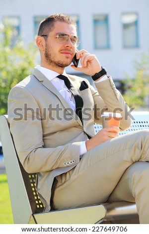 young busy businessman on the phone standing outside