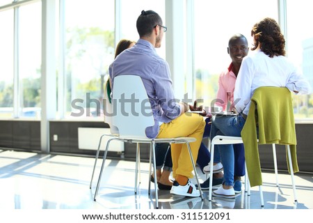 Creative business people meeting in circle of chairs