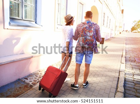 Two travelers on vacation walking around the city with luggage
