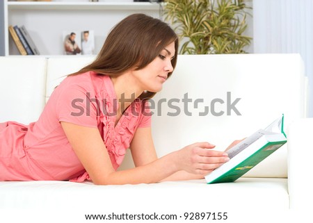 beautiful young woman on the couch with a book