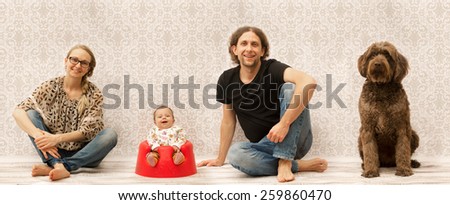 Studio photo of a happy family sitting next to each other
