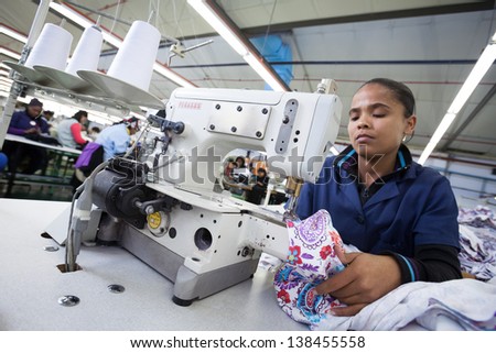 CAPE TOWN, SOUTH AFRICA - AUG 2: A woman creates a new garment in a large clothing factory in Cape Town, South Africa on August 2, 2012