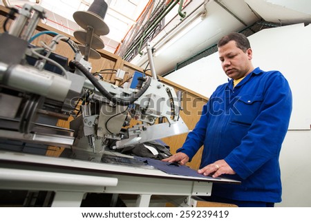 CAPE TOWN, SOUTH AFRICA - AUG 2: A man creates a new garment in a large clothing factory in Cape Town, South Africa on August 2, 2012