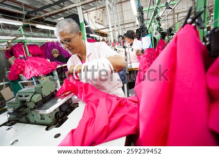 CAPE TOWN, SOUTH AFRICA - AUG 2: A woman creates a new garment in a large clothing factory in Cape Town, South Africa on August 2, 2012