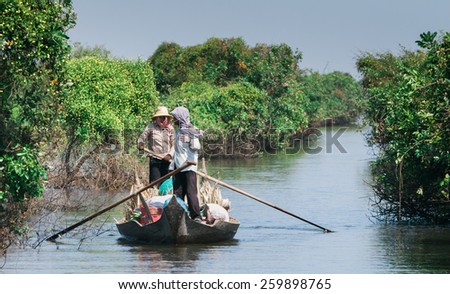 SIEM REAP, CAMBODIA - DECEMBER 09: Locals paddle a boat down one of many channels in the wetland, in Siem Reap, Cambodia on December 09, 2009