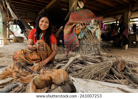 BATTAMBANG, CAMBODIA - MAY 15: A rural woman breaks apart coconut husks, in Battambang, Cambodia, on May 15, 2012