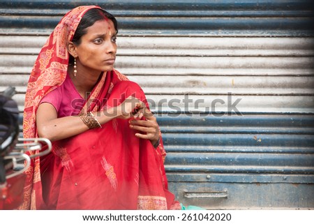 DELHI, INDIA - SEPTEMBER 14: A woman sits on the side of the road, in Delhi, India on September 14, 2010