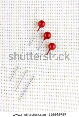 Three sewing pins in canvas textile