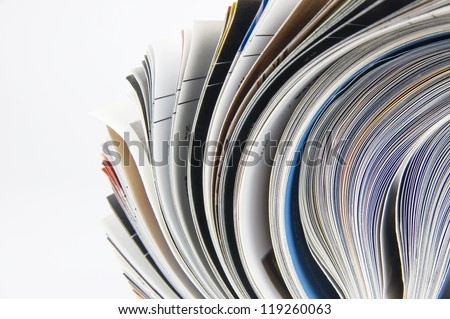 Rolled up magazines pages close-up over white background