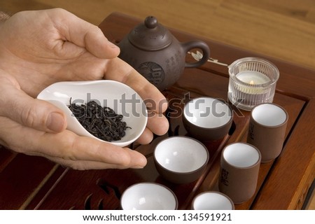 Tea in hands of tea ceremony master close up.  Fragment of tea ceremony called Acquaintance with tea