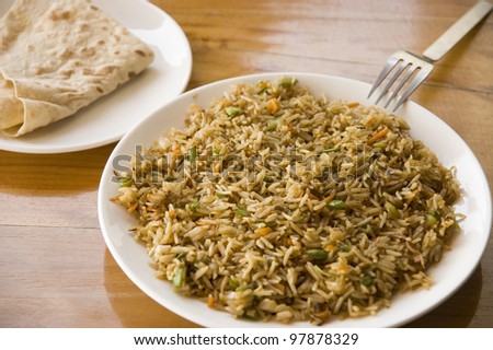 Indian cuisine: plate of vegetable fried rice and chapati (sort of Indian bread)