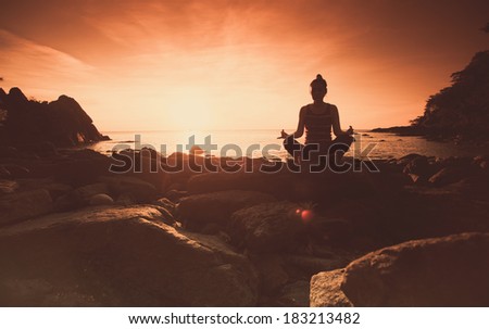 Yoga with young woman on sunset sky.