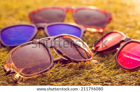 Collection of sunglasses on grass background