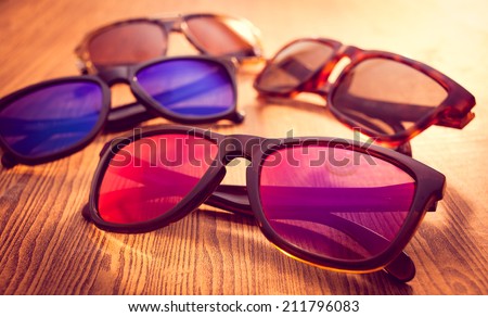 Collection of sunglasses on wood background