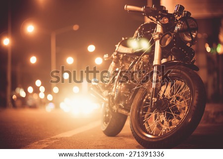 Vintage motorcycle on  road at night towards city